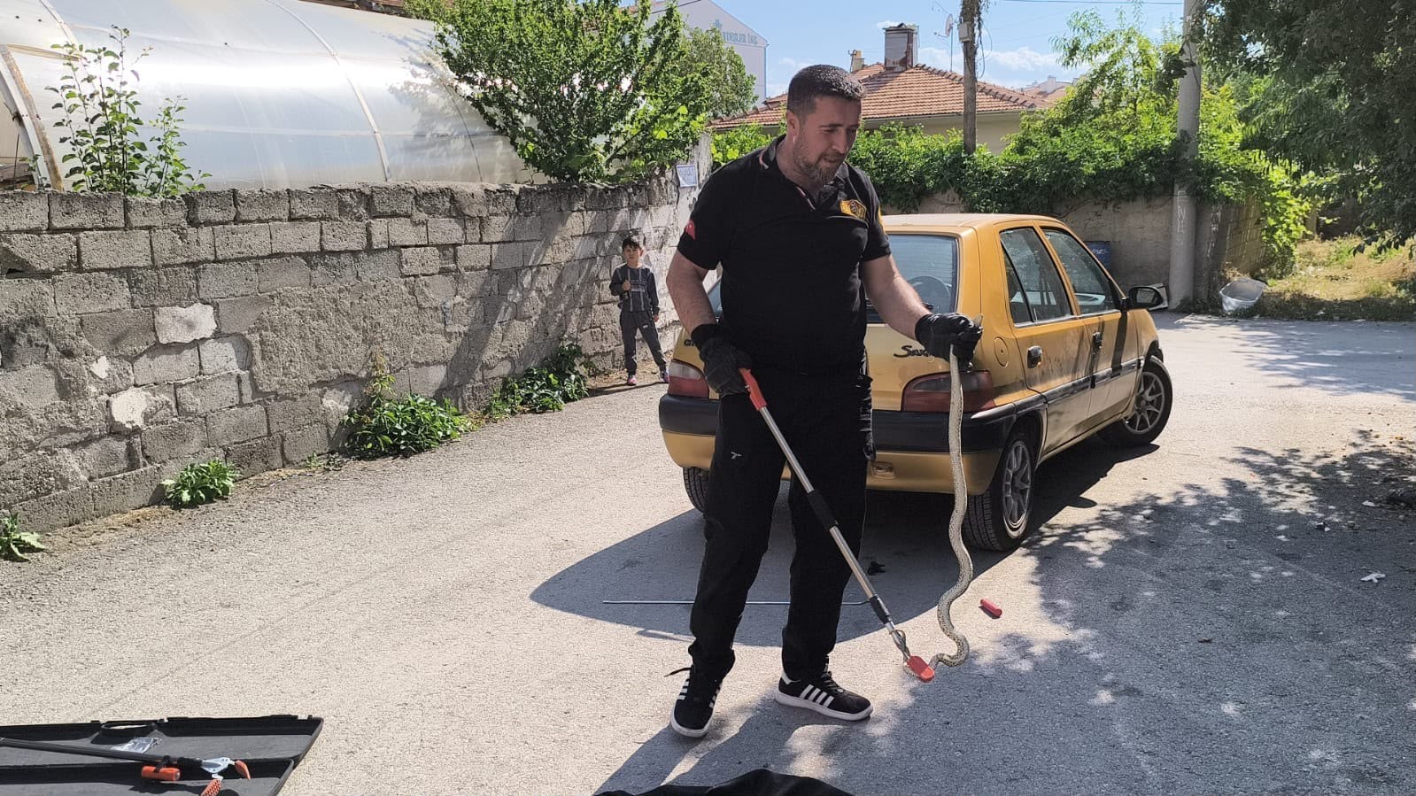 Otomobilin altına giren yılan itfaiye ekiplerince çıkarıldı