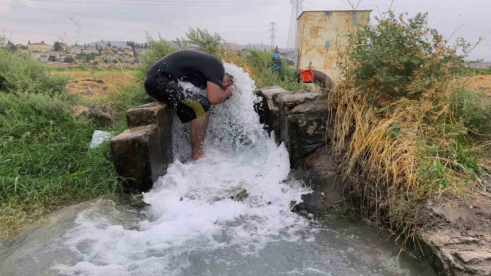 Kavurucu sıcakta elbisesini bile çıkarmadan buz gibi sondaj suyunda serinledi