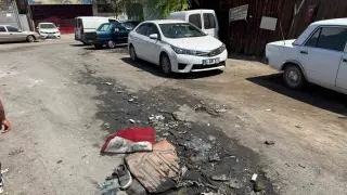 Sokaktaki derin çöküntü ve içine dolan atıklar